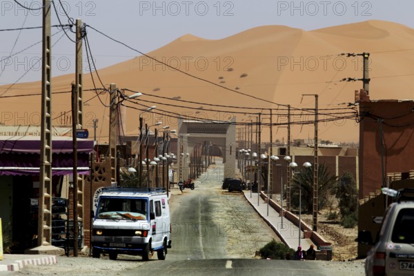 City scene near Merzouga with sand dunes in the background, Merzouga, Morocco