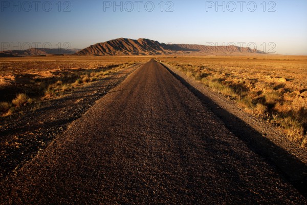 Deserted road leads through vast, dry countryside near Gourrama, Gourrama, Morocco