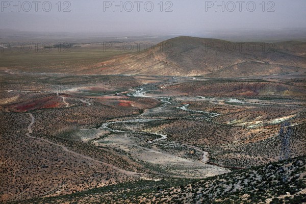 Wide, dry landscape with rolling hills and meandering river, Midelt, Morocco