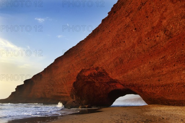 The red rock arch rises impressively on the beach coast, Legzira, Souss-Massa region, Morocco