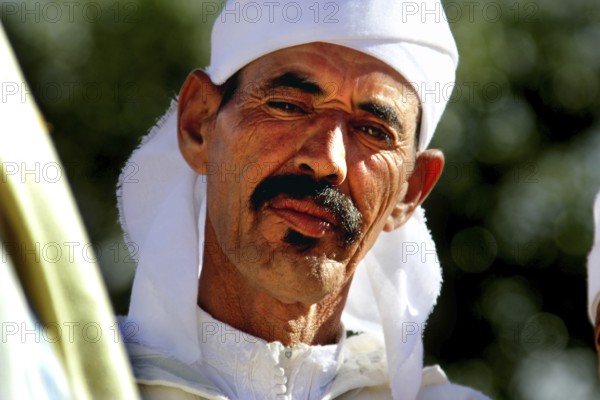 Man in traditional dress at the Rose Festival in El Kelâa m'Gouna, serious expression, El Kelâa m'Gouna, null, Morocco