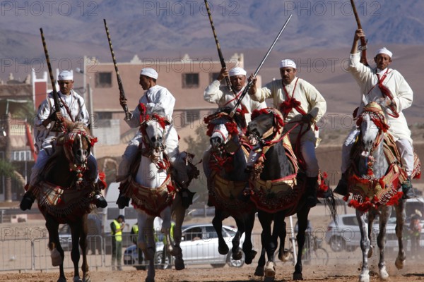 Riders riding decorated horses in an impressive formation at Fantasia, El Kelâa m'Gouna, Morocco
