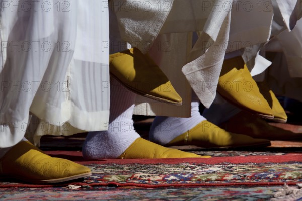Close-up of traditional yellow Berber footwear on an ornate carpet, El Kelâa m'Gouna