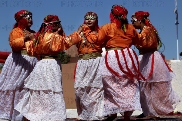Women in traditional Berber garments dance during a festival, El Kelâa m'Gouna