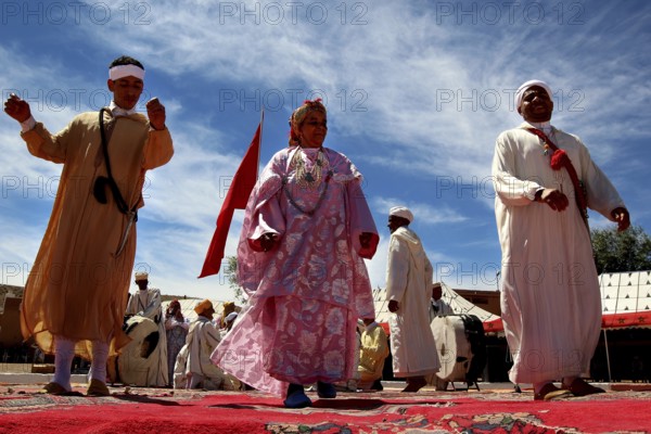 Scene of men wearing traditional Berber clothes during a celebratory dance performance, El Kelâa m'Gouna