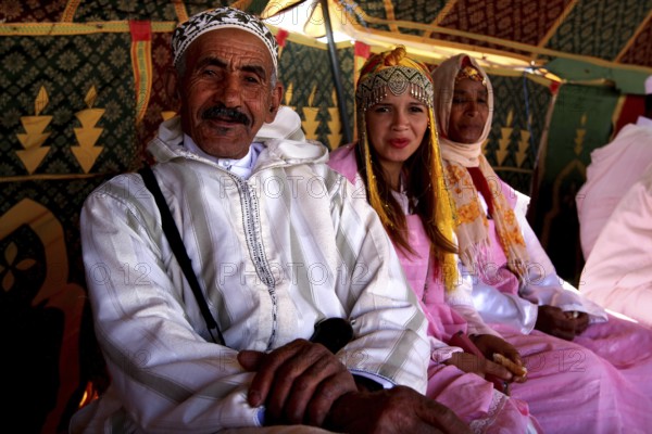 Traditional clothing and cultural atmosphere in the participant tent at the Fête des Roses, El Kelâa m'Gouna, Drâa-Tafilalet, Morocco