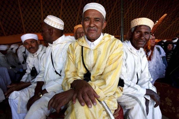 Men in traditional clothing in the participant tent during the Fête des Roses, El Kelâa m'Gouna, Drâa-Tafilalet, Morocco