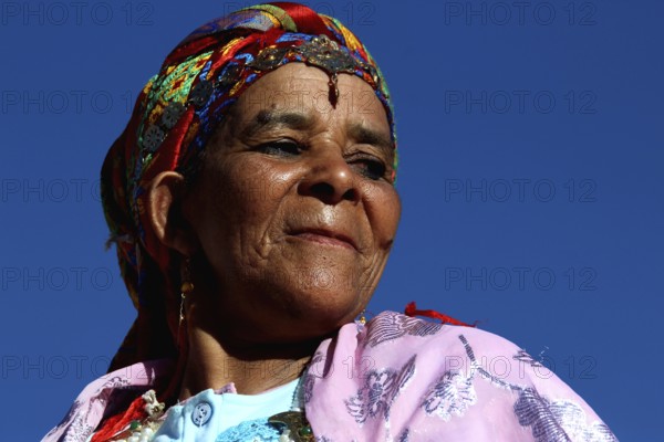 Woman wearing colorful traditional clothing and headdress at the Rose Festival in El Kelâa m'Gouna, El Kelâa M'gouna, null, Morocco