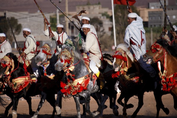 Equestrian group in traditional Moroccan costumes presents military choreographies on horses, El Kelâa m'Gouna, Morocco