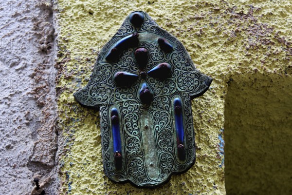 Hamsa hand relief as a decorative element on a wall in Essaouira, Essaouira, Morocco