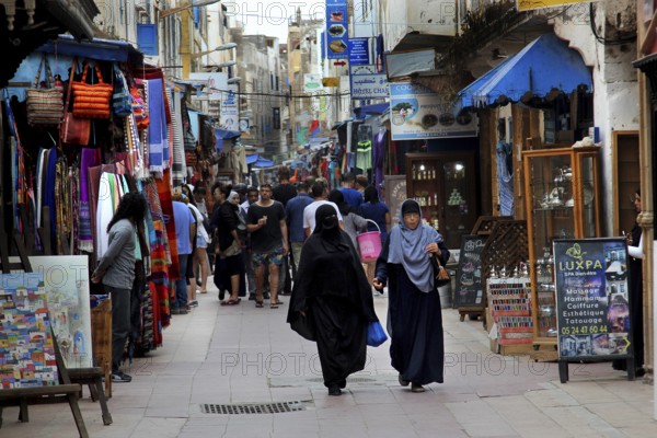 Bustling market street in Essaouira souk with many passers-by, Essaouira, Morocco
