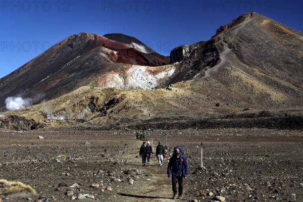 Hikers on Tongariro Alpine Crossing with views of Mount Tongariro and Mount Ngauruhoe, Tongariro National Park, North Island, New Zealand