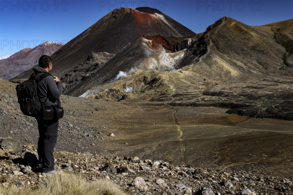 Hiker looking at Mount Ruapehu, Tongariro and Ngauruhoe, Tongariro National Park, North Island, New Zealand
