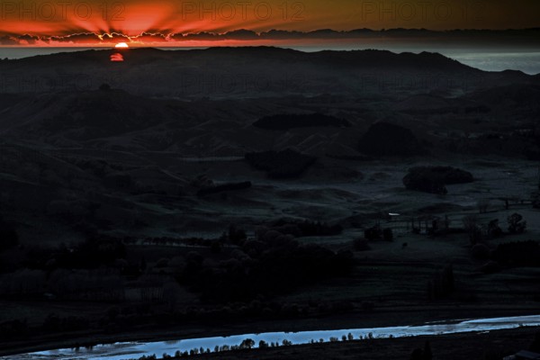 Dramatic sunrise behind mountain landscape with intense colors, Te Mata Peak, New Zealand