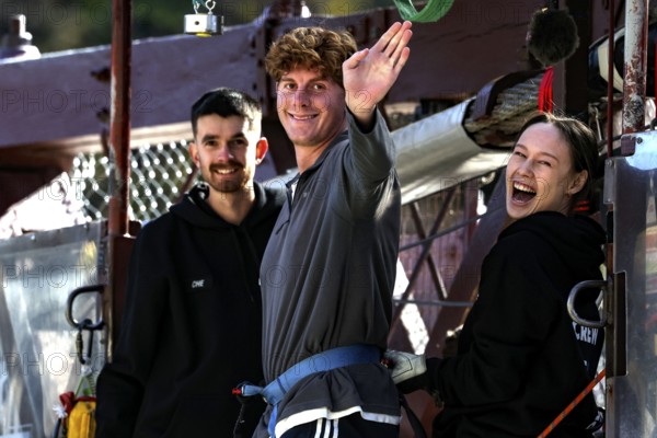 Person in front of bungee jump smiling surrounded by friends at Kawarau Bridge, Queenstown, Kawarau Bridge, New Zealand