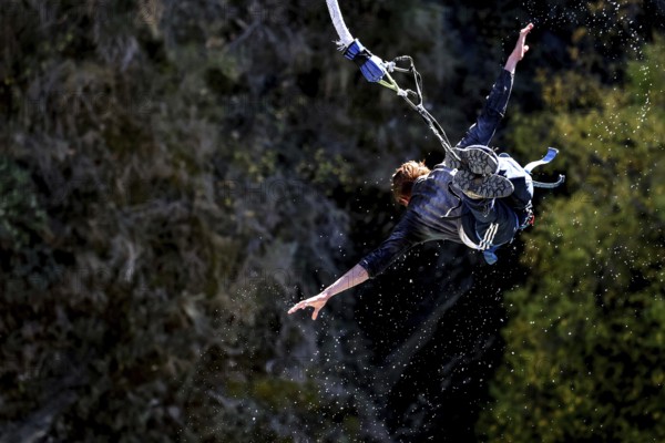 Person in a spread flight position bungee jumping over the countryside, Queenstown, Kawarau Bridge, New Zealand