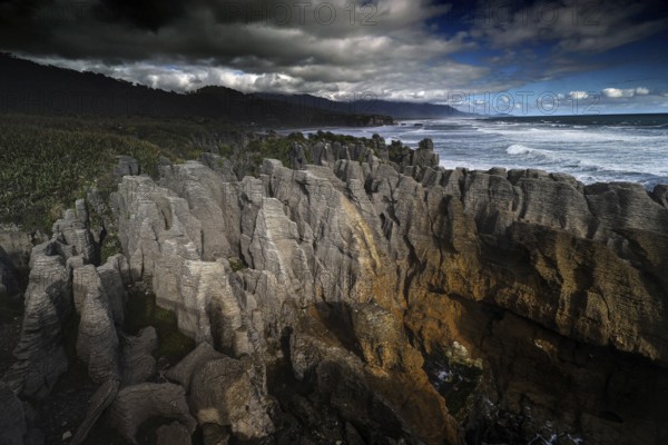 Dramatic coastal landscape with bizarre rock formations on the stormy sea