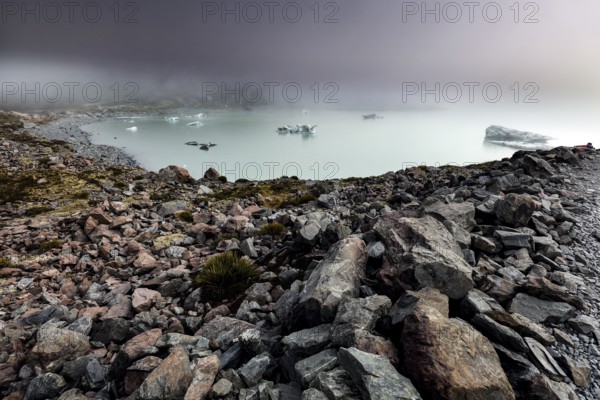 Cold glacial lake on Hocker Valley Track with rugged rocks and fog, Mt Cook, Hocker Valley Track, New Zealand