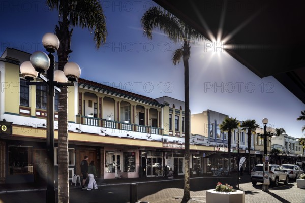 Art Deco street scene with flare sun effect and palm trees, Napier, Hawke's Bay, New Zealand