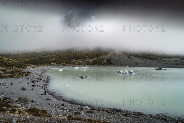 Glacial lake in misty Aoraki Mt Cook National Park with rugged shores, Mt Cook, Hocker Valley Track, New Zealand