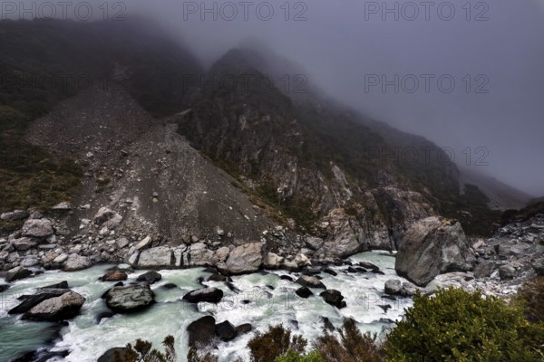 Rocky mountain landscape in fog with wild river in Hocker Valley, New Zealand, zero