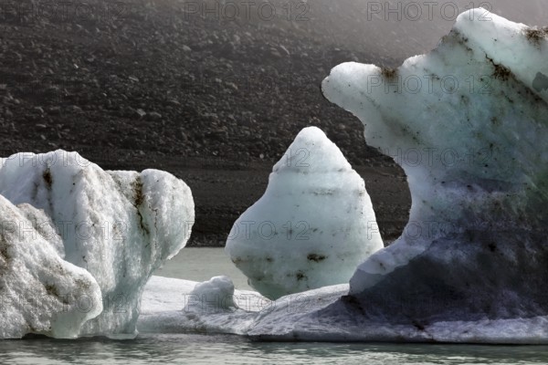 Contrasting ice blocks float in a cool glacial lake, Mount Cook, New Zealand