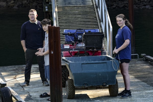 Group of people load luggage on a pier at Pelorus Mailrun