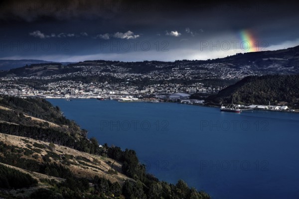 View of Dunedin with rainbow over harbor in beautiful landscape, Dunedin, Otago, New Zealand