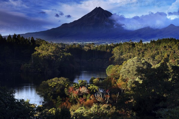 Mount Taranaki above Lake Mangamahoe, surrounded by lush green nature, New Zealand, zero