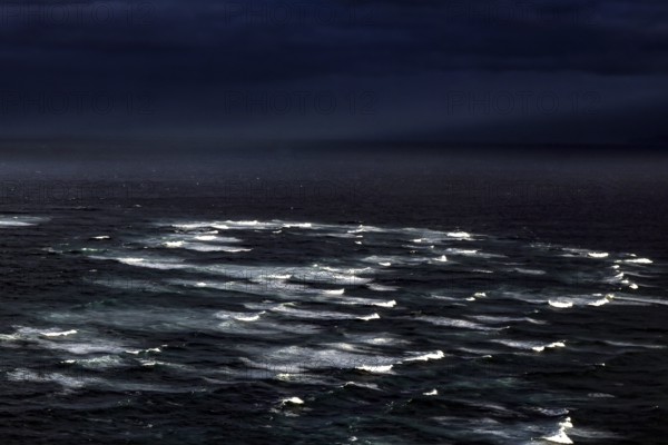 Gloomy image of the confluence of the Tasman Sea and Pacific with surging waves, Cape Reinga, Northland, New Zealand