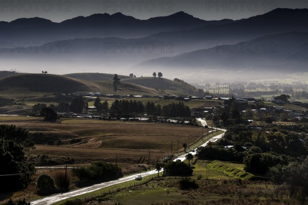 Mountainous landscape with fog covered peaks and an approaching road in Kaikoura, Kaikoura, New Zealand
