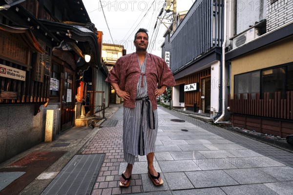 Man in yukata posing on a quiet street in Yamanouchi, Yamanouchi, Japan
