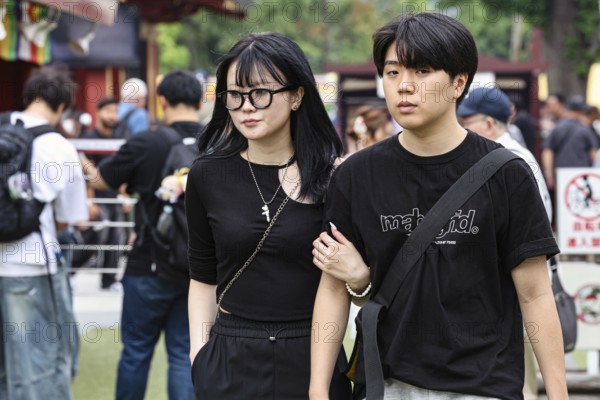A couple in black clothes walks arm in arm through Asakusa, Tokyo, Tokyo, Asakusa, Japan