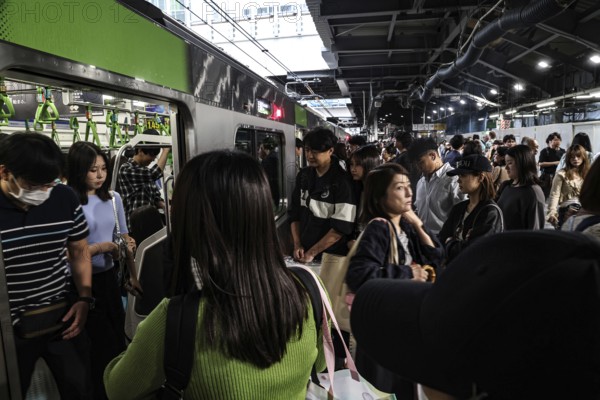 Passengers get off a train on a crowded platform in Tokyo, Tokyo, Japan