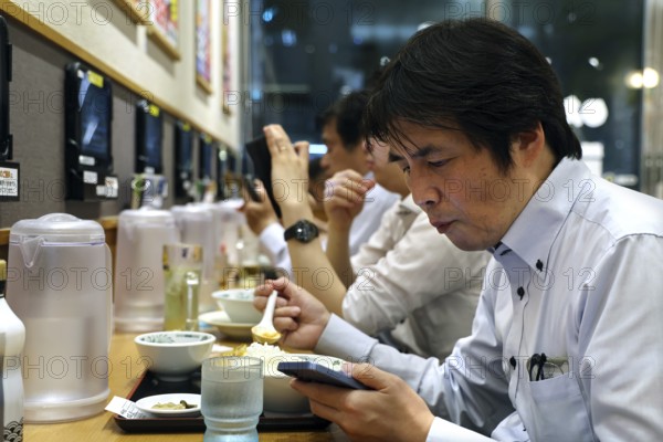 Guests at a ramen restaurant in Tokyo, engaged in eating, Tokyo, Hamamatsucho, Japan