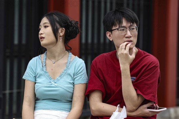 A couple sits thoughtfully on a bench in Asakusa, Tokyo, Tokyo, Asakusa, Japan