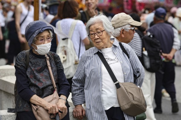 Two elderly woman talking on a busy street in Asakusa, Tokyo, Tokyo, Asakusa, Japan