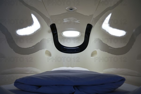 Interior of a capsule hotel sleeping capsule, futuristic design with blue pillow, Tokyo, zero, Japan