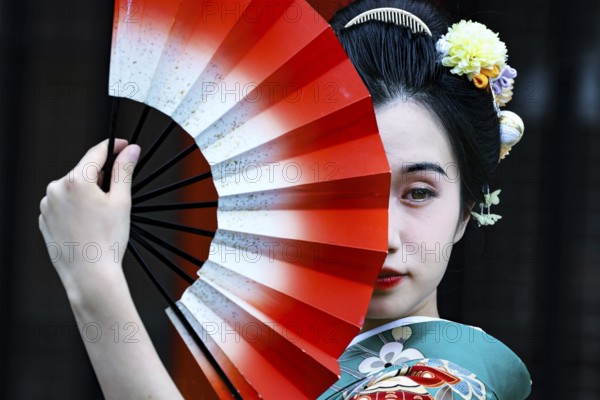 Elegant woman wearing green kimono with fans in front of Senso-ji in Asakusa, Tokyo, Asakusa, Japan
