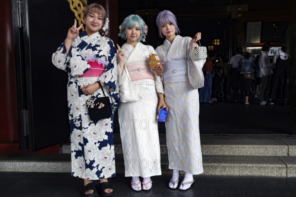 Three woman wearing white kimonos pose in front of Senso-ji in Asakusa, Tokyo, Asakusa, Japan