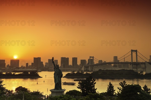 Statue of Liberty and Rainbow Bridge in the background of a sunset, Tokyo, Japan