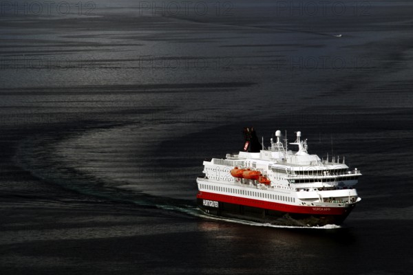 A Hurtigruten ship sails across the dark sea, Hammerfest, Finnmark, Norway