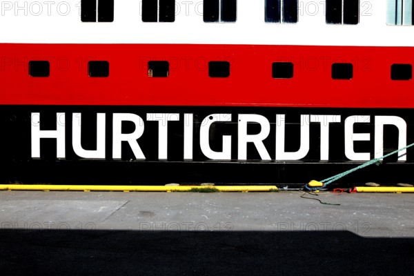 Hurtigruten lettering on a ship against a blue sky in Hammerfest, Hammerfest, Norway