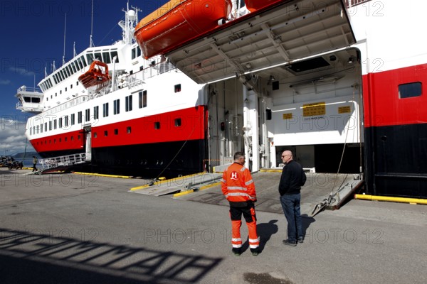 Hurtigruten ship at Hurtigrutenkai in Hammerfest with open cargo hatch and two people on the quay, Hammerfest, Finnmark, Norway