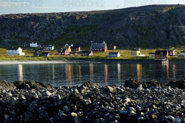 View of Hamningberg with kittiwakes along the coast and reflections in the water