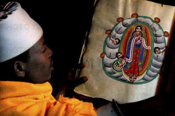 Abba Philippos is studying an artfully illustrated manuscript in the monastery church, Debre Damo, Tigray, Ethiopia