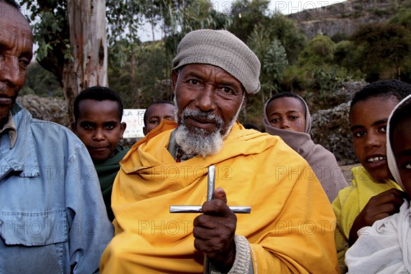 A pilgrim with a cross surrounded by other believers at Debre Libanos, Debre Libanos, Ethiopia