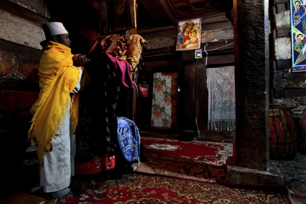 Two men in traditional robes in the richly decorated monastery church, Debre Damo, Tigray, Ethiopia