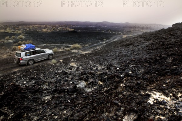 Travel through a barren lava desert with a Landcruiser on a gravel road