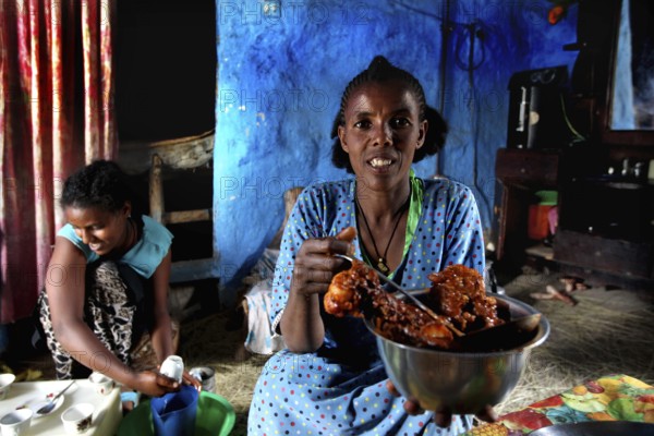 Woman having fun presenting a dish to Chuchu's family in Lalibela, Lalibela, null